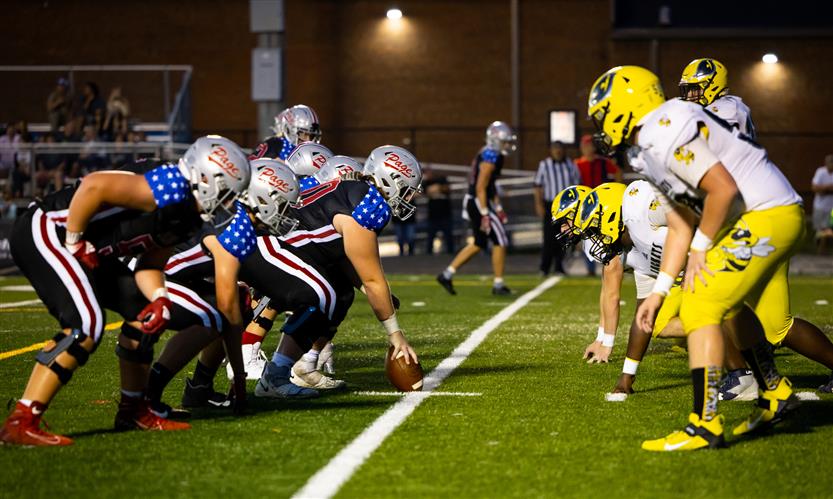 Two football teams line up to start the play